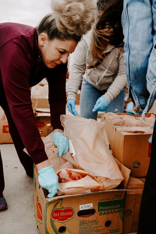 Woman packing a box at a Thanksgiving food drive